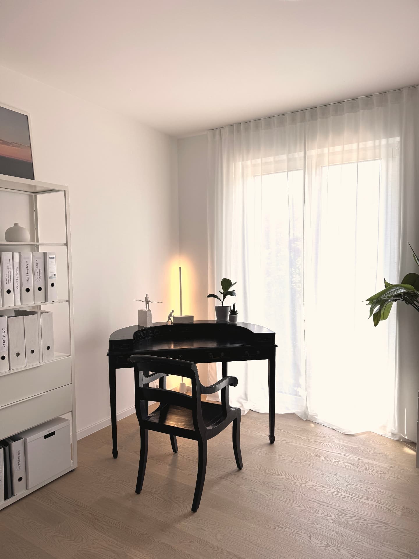 Schreibtischplatz der Praxis mit antikem Sekretär und Tageslicht am Fenster